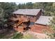 Stunning exterior view of a multi-story home with a spacious wooden deck surrounded by lush trees at 133 Mine Ln, Boulder, CO 80302