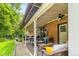 Charming covered back patio with brick accents, ceiling fan, and comfortable seating area for relaxation and entertaining at 2876 S Wolff St, Denver, CO 80236