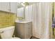 Bathroom with updated vanity, green tile, and a shower at 2876 S Wolff St, Denver, CO 80236