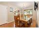 Warm dining room with a wooden table set beneath a chandelier and a view to the kitchen at 2876 S Wolff St, Denver, CO 80236