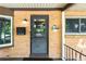 Close-up of the front door featuring brick accents, decorative fixtures, and a welcoming entry at 2876 S Wolff St, Denver, CO 80236