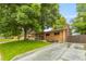 Traditional brick home featuring a cozy front porch, mature tree, and driveway at 2876 S Wolff St, Denver, CO 80236