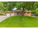 Charming brick home with a well-manicured lawn and mature tree providing shade and curb appeal at 2876 S Wolff St, Denver, CO 80236
