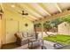 Covered patio features stylish wicker furniture, ceiling fan, and views of the landscaped backyard at 2876 S Wolff St, Denver, CO 80236