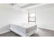 Minimalist bedroom has neutral carpet and one black-framed window at 7877 E Mississippi Ave # 901, Denver, CO 80247