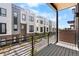Modern townhome exterior with a balcony overlooking the courtyard and manicured landscape at 9066 Harlan St, Westminster, CO 80031