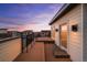 Stunning rooftop deck with wood-style flooring and a modern railing offers panoramic sunset views at 9066 Harlan St, Westminster, CO 80031