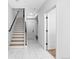 Bright entryway featuring marble tile flooring, a staircase with black railing, and a bench seat at 9066 Harlan St, Westminster, CO 80031