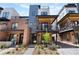 Modern townhome showcases a brick and metal exterior, complemented by a charming landscaped front yard at 9066 Harlan St, Westminster, CO 80031