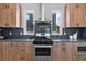 Well-appointed kitchen features sleek wood cabinetry, stainless steel appliances, and dark stone countertops at 9066 Harlan St, Westminster, CO 80031