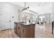 Modern kitchen with island seating flows into a bright living room, showcasing open-concept living at 9066 Harlan St, Westminster, CO 80031