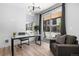 Contemporary home office featuring hardwood floors, desk, chair, and a modern light fixture at 9066 Harlan St, Westminster, CO 80031