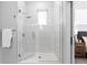 Walk-in shower with white subway tile and glass doors, illuminated by natural light from a window at 9066 Harlan St, Westminster, CO 80031