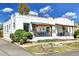 Charming bungalow featuring a white brick exterior, covered porch, and professionally landscaped front yard at 2327 Lowell Blvd, Denver, CO 80211