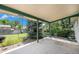 Covered patio overlooks landscaped backyard with mature trees and lush greenery at 5502 E Center Ave, Denver, CO 80246