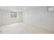 Bright basement area with white walls, carpet, and natural light from a window at 5502 E Center Ave, Denver, CO 80246