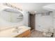 Bathroom features a vanity with a large mirror, a tiled floor, toilet, and a walk-in shower at 5502 E Center Ave, Denver, CO 80246