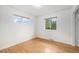 Bedroom featuring hardwood floors and two windows, creating a bright and airy space for relaxation at 5502 E Center Ave, Denver, CO 80246
