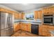 Well-lit kitchen features stainless steel appliances, wood cabinetry, and a built-in oven for culinary convenience at 5502 E Center Ave, Denver, CO 80246