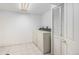 Functional laundry room with washer, dryer, tiled floor, and closet at 5502 E Center Ave, Denver, CO 80246