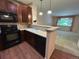 Modern kitchen with wooden cabinets, black appliances, and breakfast bar overlooking living area at 11207 Osage Cir # B, Northglenn, CO 80234