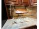 Close-up of countertop with marble detail, wooden cabinets, and slide out cutting board at 11207 Osage Cir # B, Northglenn, CO 80234