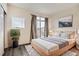 Stylishly staged bedroom with wood floors, bed with rug, a houseplant, and a large glass door at 18847 E Yale Cir # D, Aurora, CO 80013