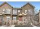 Multi-level townhome exhibits balcony, stone accents, red entry door, and xeriscaping at 18847 E Yale Cir # D, Aurora, CO 80013