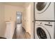 Hallway with wood-look flooring, white walls, laundry, and view to other rooms at 18847 E Yale Cir # D, Aurora, CO 80013