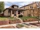 Charming brick home with a well-manicured lawn, garden beds, and an inviting front porch at 840 S Pennsylvania St, Denver, CO 80209