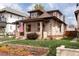 Charming brick home with a cozy front porch, a well-maintained lawn, and garden beds at 840 S Pennsylvania St, Denver, CO 80209