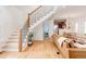 Open-concept living room with hardwood floors, a staircase, and a view into the dining and kitchen areas at 840 S Pennsylvania St, Denver, CO 80209