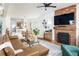 Open-concept living area with a brick fireplace, hardwood floors, and a modern ceiling fan at 840 S Pennsylvania St, Denver, CO 80209