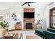 Bright living room featuring a decorative brick fireplace, hardwood floors, and stylish furnishings at 840 S Pennsylvania St, Denver, CO 80209