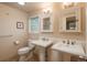 Classic bathroom with double pedestal sinks and updated vanity at 6941 S Poplar Way, Centennial, CO 80112