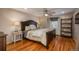 Bedroom with hardwood floors, built-in shelving and large window at 6941 S Poplar Way, Centennial, CO 80112