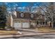 Two-story house with attached two-car garage and mature trees in the front yard at 6941 S Poplar Way, Centennial, CO 80112