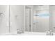 Bright bathroom featuring double sinks, sleek fixtures, and a glass-enclosed shower at 8807 Sedalia St, Commerce City, CO 80022