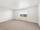 This bedroom features neutral paint, plush carpet, and a window at 8807 Sedalia St, Commerce City, CO 80022