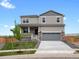 Two-story home featuring stone accents and a two-car garage on a sunny day at 8807 Sedalia St, Commerce City, CO 80022