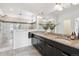A spacious bathroom features a large mirror, dual sinks, a glass shower, and modern fixtures at 11466 E 27Th Ave, Denver, CO 80238