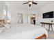 Bright bedroom featuring a ceiling fan, natural light, and access to the bathroom and hall at 11466 E 27Th Ave, Denver, CO 80238