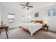 Bright bedroom featuring a ceiling fan, natural light, and a wooden bed frame with a white comforter at 11466 E 27Th Ave, Denver, CO 80238