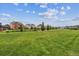 Expansive green common area in residential community with single Gathering homes and walking path at 11466 E 27Th Ave, Denver, CO 80238