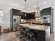 Modern kitchen features dark cabinets, granite island with seating, and stainless steel appliances at 11466 E 27Th Ave, Denver, CO 80238