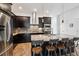 Modern kitchen features dark cabinets, granite island with seating, and stainless steel appliances at 11466 E 27Th Ave, Denver, CO 80238