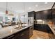 Spacious kitchen with granite counters, stainless appliances, island with sink and dark wood cabinetry at 11466 E 27Th Ave, Denver, CO 80238