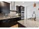 Modern kitchen boasts granite countertops, stainless steel appliances, and ample dark wood cabinetry at 11466 E 27Th Ave, Denver, CO 80238