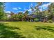 Expansive backyard featuring a well-maintained lawn, mature trees, and a covered patio area at 5914 S Kearney St, Centennial, CO 80111