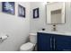 Chic half bath with blue vanity, quartz countertop, and fern-themed wall art at 5914 S Kearney St, Centennial, CO 80111